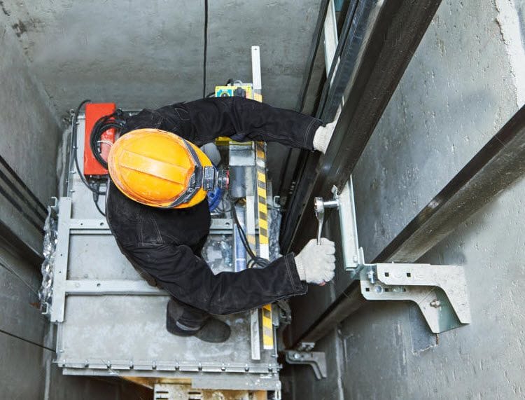 Equipe especializada realizando manutenção preventiva em elevador